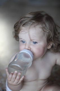 Caucasian baby girl drinking bottle