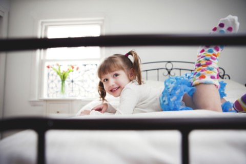 Smiling girl playing on bed
