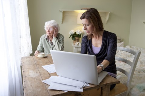 Woman paying bills for elderly mother