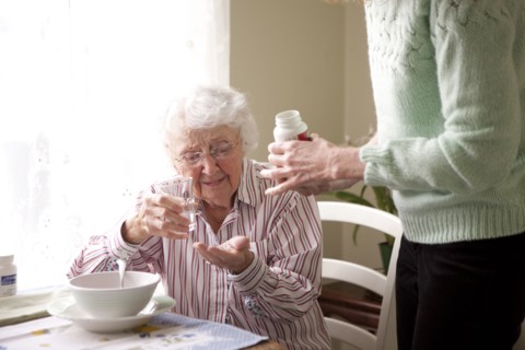 Woman giving mother medication