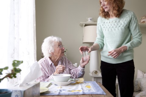 Woman giving mother glass of water