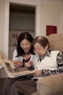 Asian mother and daughter looking at photo album