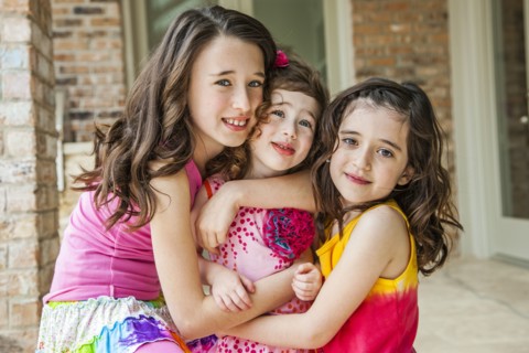 Playful sisters hugging outdoors