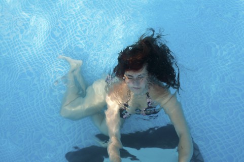 Caucasian woman swimming in pool