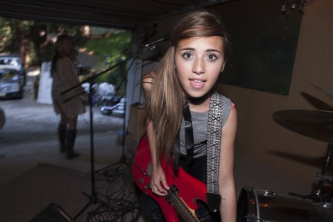 Girl playing guitar in rock band