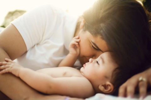 Mixed race mother nuzzling baby