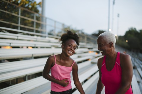Grandmother and granddaughter standing on bleachers