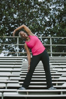 Woman stretching on bleachers