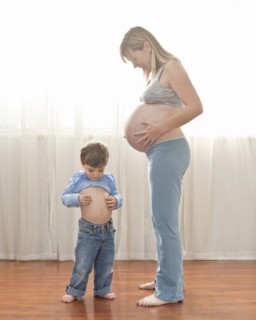 Caucasian boy imitating pregnant mother
