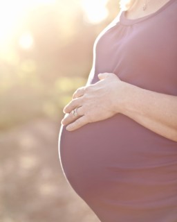 Pregnant Caucasian woman caressing stomach