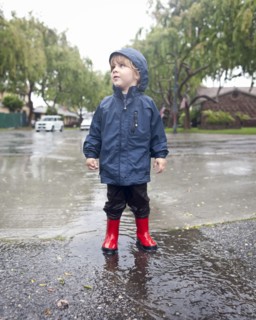 Caucasian boy standing in rain