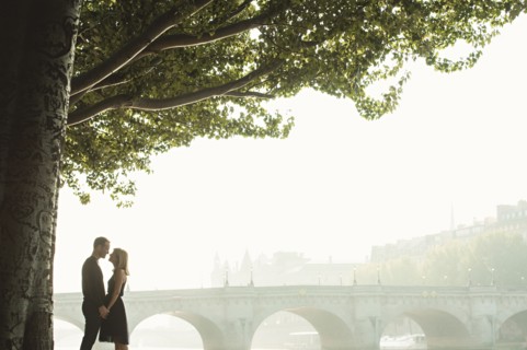 Caucasian couple kissing near bridge