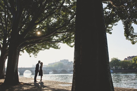 Caucasian couple kissing near bridge