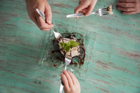 High angle view of hands reaching for food on plate