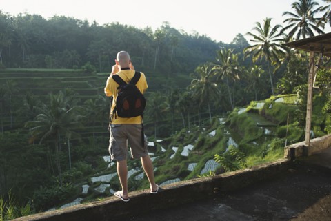 Caucasian tourist photographing rural rice terrace