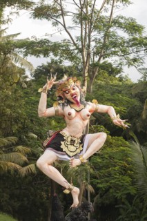 Statue of dancing deity in lush forest