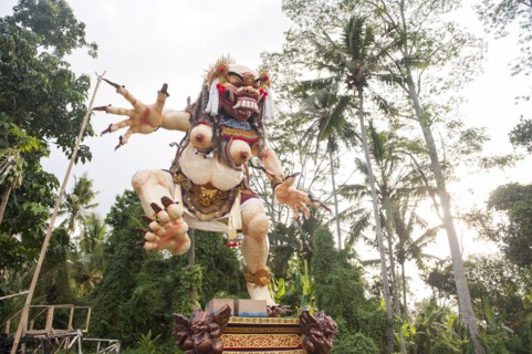 Statue of dancing deity in lush forest