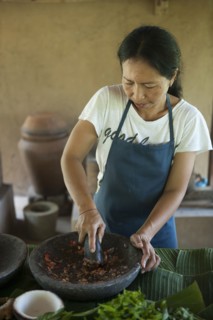 Asian chef grinding spices in outdoor kitchen