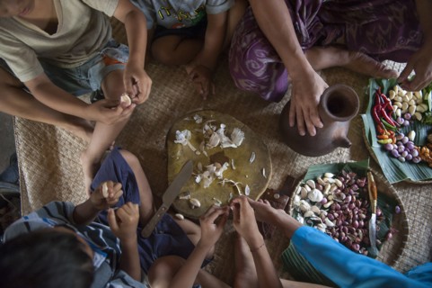 Asian family eating on woven mat