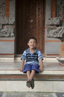 Asian boy sitting outside ornate building