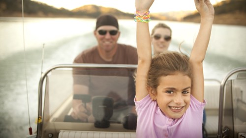 Girl and parents enjoying riding on boat