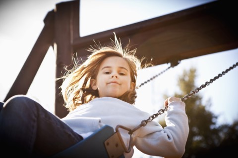 Caucasian girl swinging