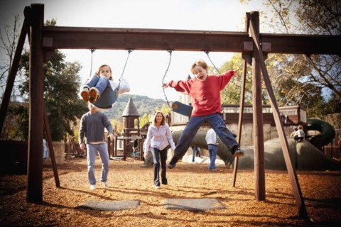 Parents watching children swinging