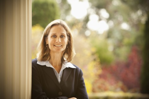 Caucasian businesswoman leaning against post