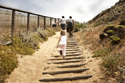 Family walking up sandy staircase