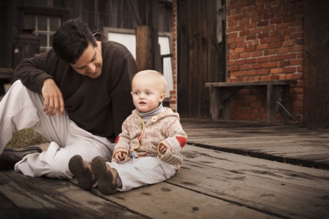 Caucasian father sitting on floor with son
