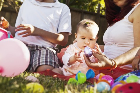 Hispanic baby playing with Easter eggs