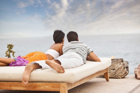 Hispanic couple relaxing near ocean