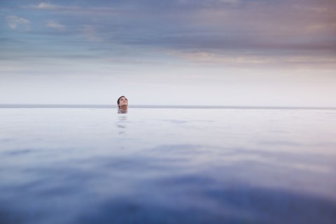 Hispanic woman soaking in swimming pool