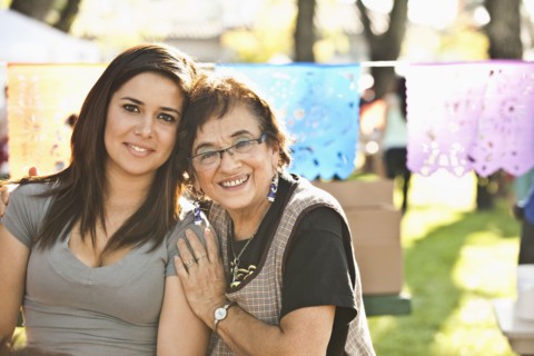 Smiling Hispanic grandmother and granddaughter