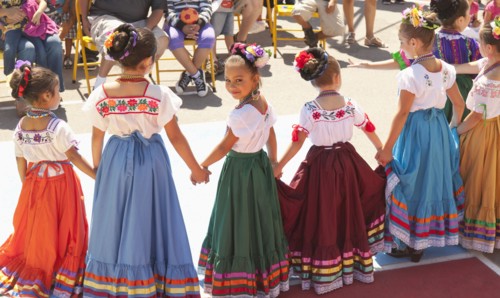 Hispanic girls dancing in costumes