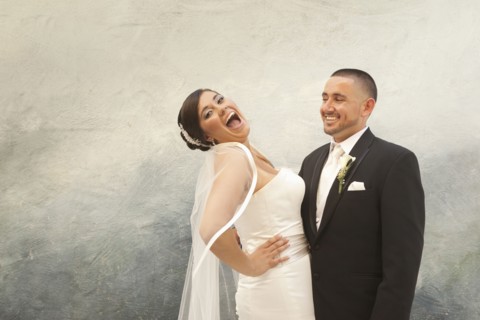 Hispanic bride and groom laughing