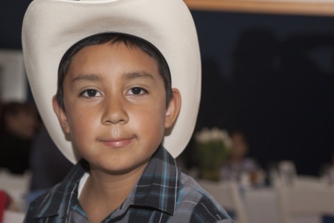 Hispanic boy wearing cowboy hat