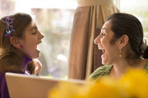 Mother and daughter talking at computer