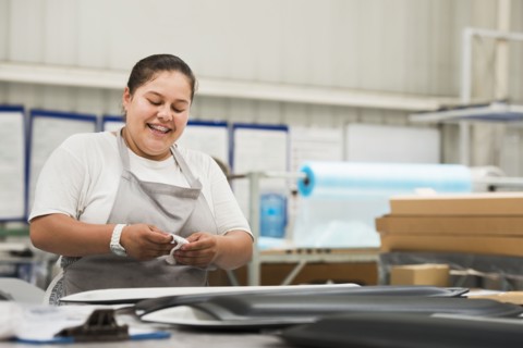 Worker smiling in manufacturing plant