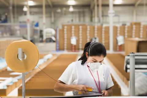 Worker wearing face mask in manufacturing plant