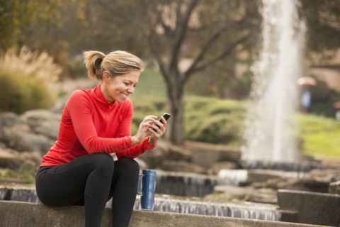 Caucasian woman using cell phone in park