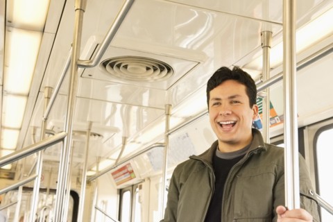 Hispanic man laughing on train