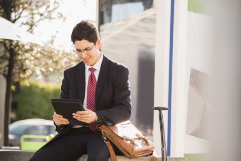 Hispanic businessman using tablet computer