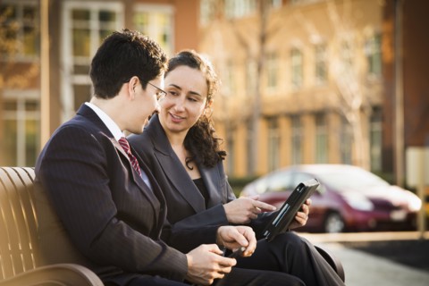 Hispanic business people using tablet computer