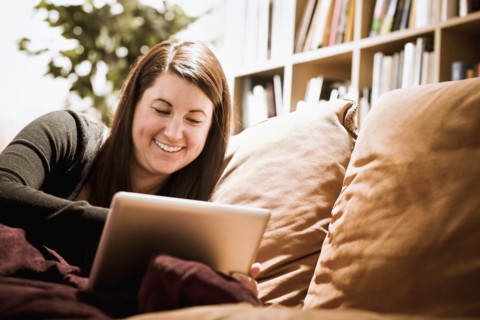 Caucasian woman using digital tablet on sofa