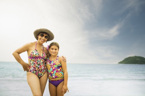 Mother and daughter smiling on beach