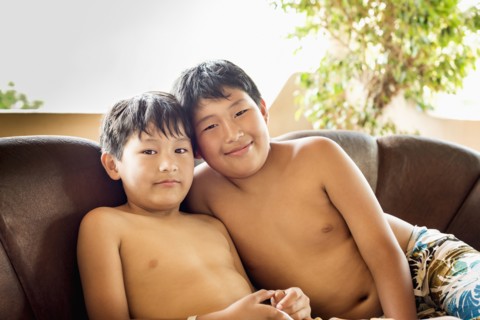 Hispanic boys smiling on sofa