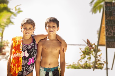Mixed race children smiling on beach