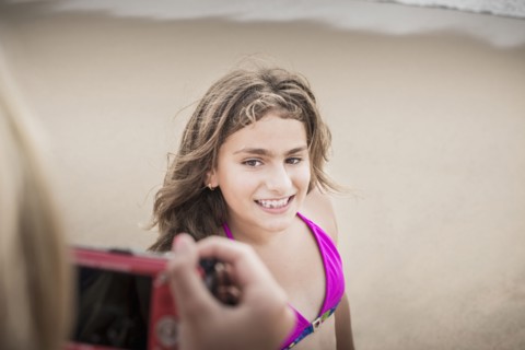 Girl posing for photograph on beach