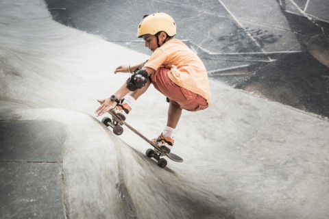 Mixed race boy riding skateboard in skate park